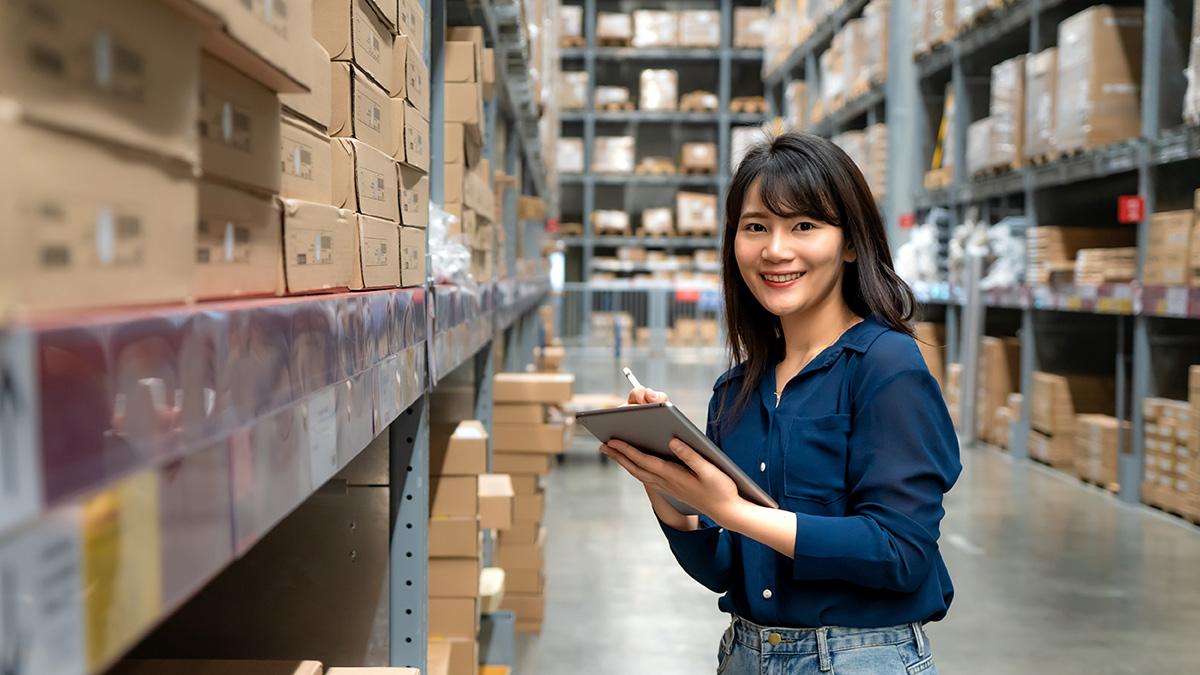 Worker standing a warehouse with a clipboard